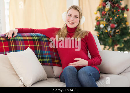 Beautiful pregnant woman sitting on a couch Banque D'Images