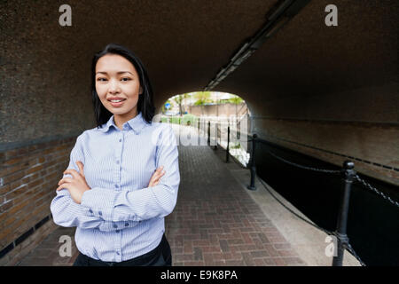 Portrait of businesswoman standing arms crossed par canal Banque D'Images