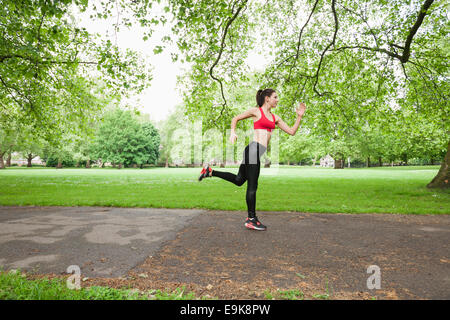 Vue latérale sur toute la longueur de la fit woman jogging in park Banque D'Images