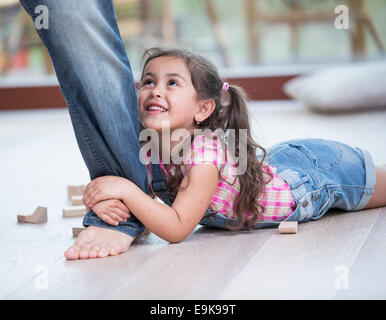 La section basse de père fille faisant glisser sur plancher de bois franc Banque D'Images