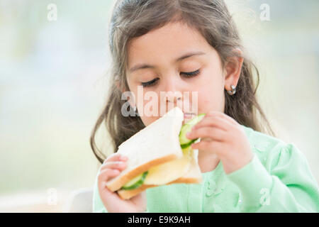 Cute girl eating sandwich à la maison Banque D'Images