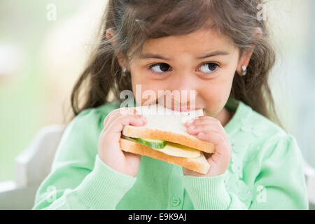 Little girl eating sandwich à la maison Banque D'Images