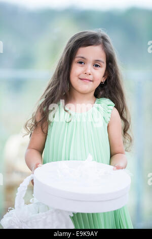 Portrait of cute girl holding gift box et panier à l'accueil Banque D'Images