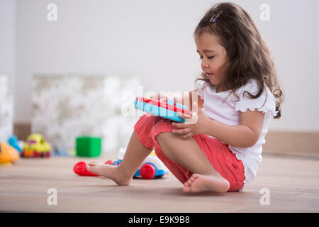 Cute girl Playing with toy guitar at home Banque D'Images