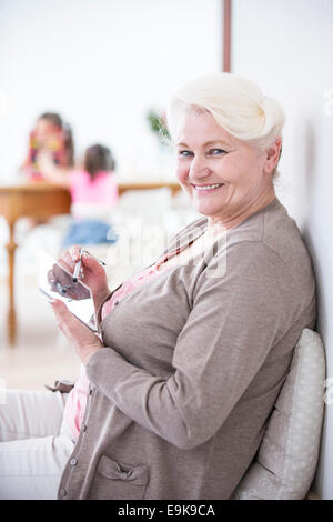 Portrait of senior woman using digital tablet avec stylet à la maison Banque D'Images