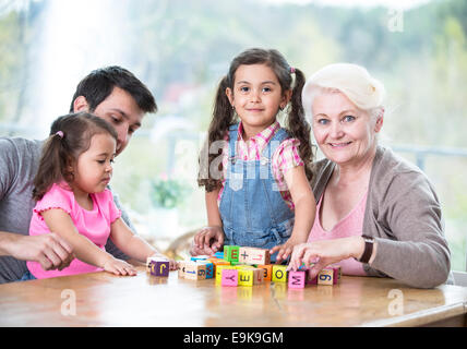 Happy three generation family Playing with alphabet blocks à la maison Banque D'Images