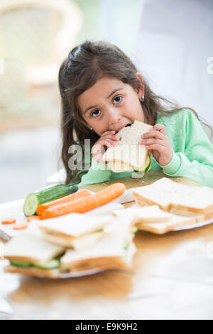 Portrait of Girl eating sandwich à la maison Banque D'Images