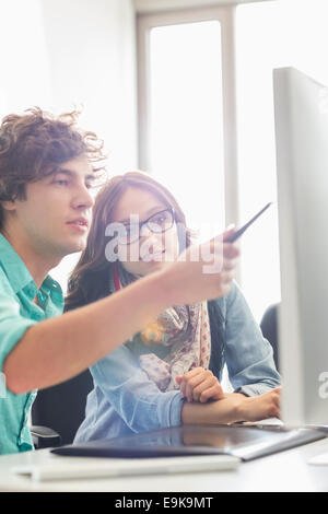 Creative business colleagues discussing sur desktop computer in office Banque D'Images