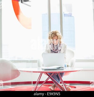 Businesswoman using laptop in creative office Banque D'Images