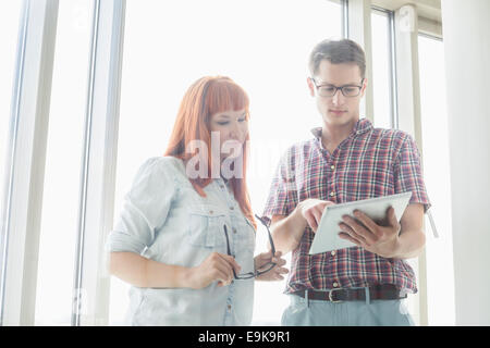 Creative businesspeople using digital tablet together in office Banque D'Images