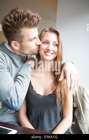 Jeune homme romantique kissing woman in cafe Banque D'Images