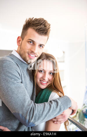 Portrait de jeune homme aimant hugging woman at cafe Banque D'Images