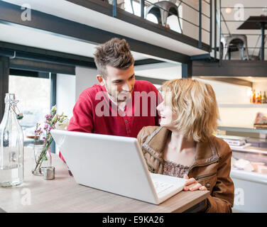 Young woman while using laptop in cafe Banque D'Images