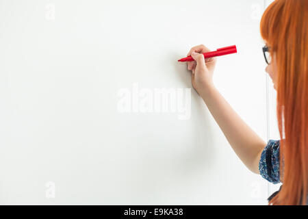 Portrait des femmes d'écrire sur le tableau blanc dans creative office Banque D'Images