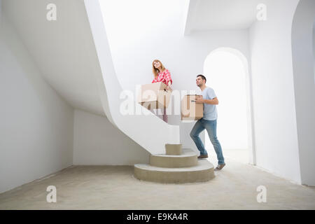 Couple de boîtes de carton vers le haut des escaliers in new house Banque D'Images