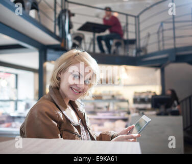 Portrait of smiling young woman using tablet PC in cafe Banque D'Images