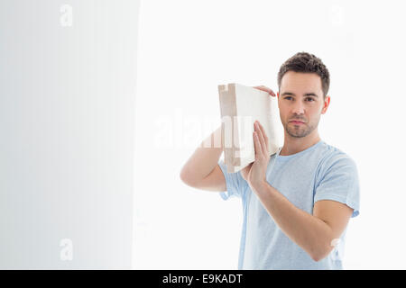 Mid-adult man carrying lumber sur l'épaule Banque D'Images