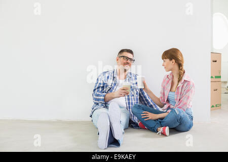 Full-length of couple having coffee in new house Banque D'Images