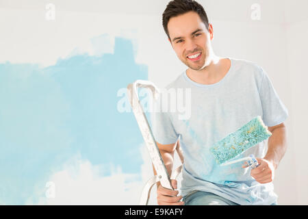 Portrait of happy man painting sa nouvelle maison Banque D'Images