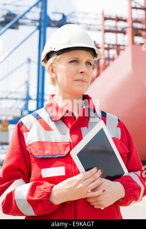 Ingénieur femelle holding tablet computer in shipping yard Banque D'Images