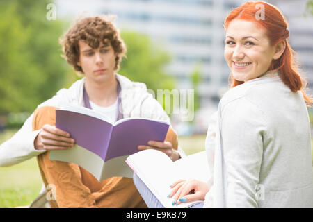 Portrait of happy young woman with ami masculin étudiant au campus du collège Banque D'Images