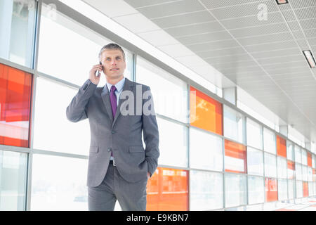 Middle aged businessman using cell phone at train station Banque D'Images