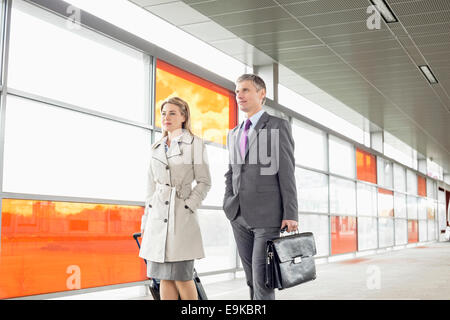 Businesspeople with luggage walking in railroad station Banque D'Images