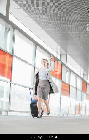 Toute la longueur de young businesswoman with assurance se précipiter à railroad station Banque D'Images