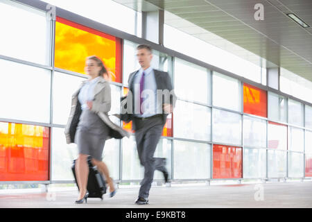 Businessman and businesswoman rushing dans railroad station Banque D'Images