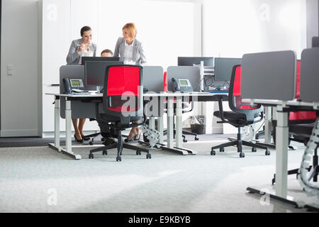 Les gens d'affaires du déjeuner tandis que using computer in office Banque D'Images