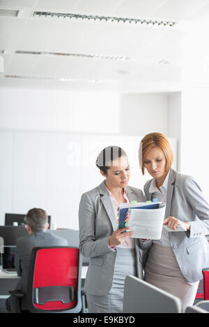 Businesswoman discussing over book in office Banque D'Images