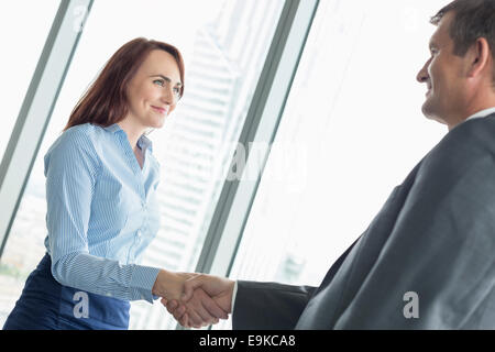 Vue latérale du business people shaking hands in office Banque D'Images