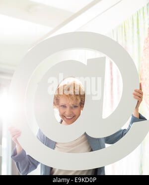 Portrait of happy businesswoman looking at sign in creative office Banque D'Images