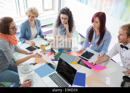 High angle view of businesspeople analyser des photographies dans creative office Banque D'Images