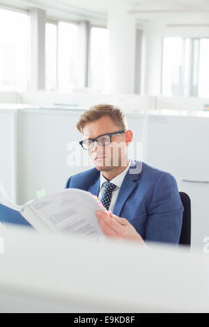 Businessman reading file in creative office Banque D'Images
