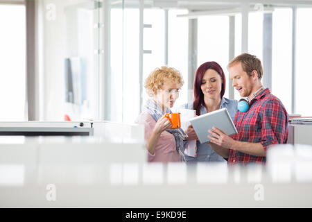 Businessman with female colleagues discussing sur tablet PC in office Banque D'Images