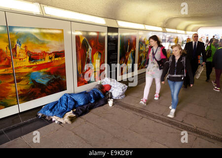 Poverty UK; Homeless UK; personnes passant devant un sans-abri dormant dans la rue dans un sac de couchage, Tower Hill, Londres, Royaume-Uni Banque D'Images