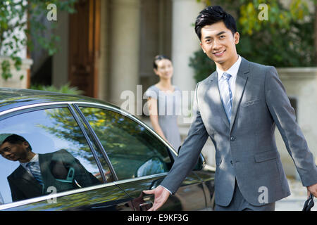 Jeune homme d'ouverture de porte de voiture Banque D'Images