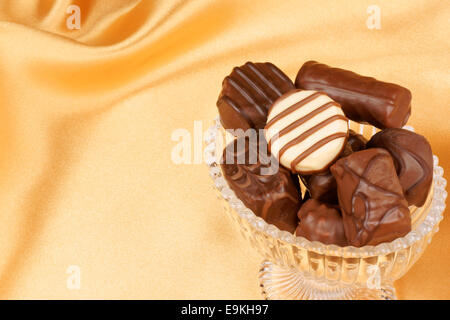 Close-up of assortiment de pralines en chocolat sur un fond de tissu jaune, avec l'exemplaire de l'espace. Banque D'Images