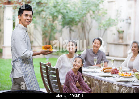 Jeune homme pour sa famille cuisson corns Banque D'Images