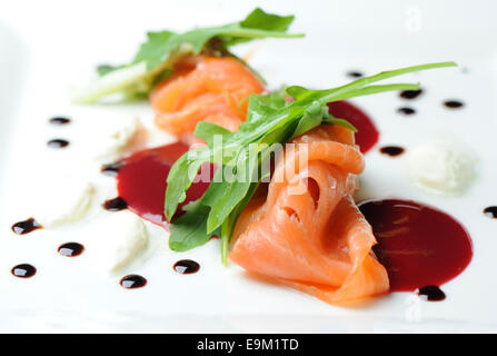 Gravlax de saumon fumé servi en entrée sur une assiette blanche avec la sauce chili. Banque D'Images