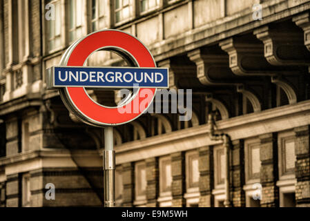 LONDRES, Royaume-Uni — L'emblématique panneau London Underground, avec un cercle rouge avec une barre bleue, marque l'entrée d'une station de métro. Connu sous le nom de « cocarde », ce symbole est un emblème largement reconnu du système de transport public londonien. Le métro de Londres, communément appelé le métro, est l'un des réseaux de métro les plus anciens et les plus étendus au monde. Banque D'Images