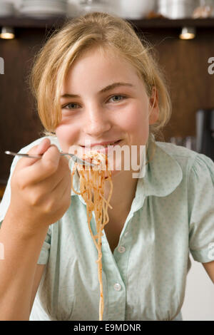 Teenage girl eating spaghetti Banque D'Images