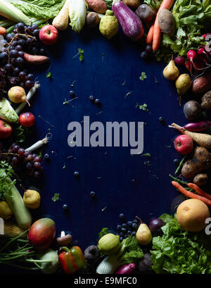 Tourné directement au-dessus des fruits et légumes frais formant cercle sur tableau bleu Banque D'Images