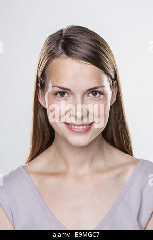 Close-up portrait of smiling young woman against white background Banque D'Images