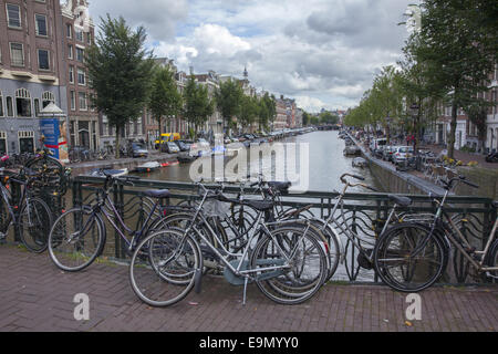 Bateaux Bicyclettes et voitures le long d'un canal principal d'Amsterdam, Pays-Bas. Banque D'Images