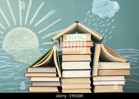 Concept de l'éducation inhabituels. L'École de livres sur fond de dessin à la craie de soleil et de pluie. Banque D'Images