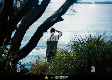 Jeune homme debout sur une falaise, l'Australie Banque D'Images