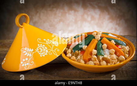 Tajine de légumes à couscous sur table en bois. Banque D'Images