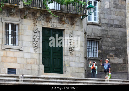 Touristes prenant des photos à côté de la porte d'entrée de la Casa da Parra, Praza da Quintana, Santiago de Compostelle, Galice, Espagne Banque D'Images